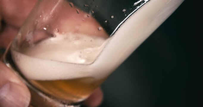 Beer being filled into glass close up in industrial factory brewery