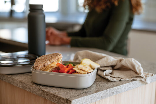 A beautifully arranged healthy lunch box filled with a sandwich, fresh vegetables, and a fruit, perfect for a nutritious meal prep option for busy days ahead.