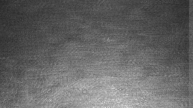 Abstract dark grey textured surface with subtle light gradient.