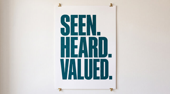 A printed poster with bold teal text reading seen heard valued hanging on a wall with typography hanging plain white poster words communication affirmation