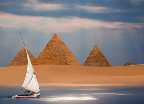 Beautiful Nile scenery with traditional Felluca sailing boat in the Nile on the way to Giza pyramids at dusk  - Cairo, Egypt
