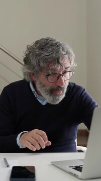 Mature businessman celebrating success at laptop