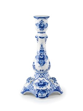 A ceramic candlestick stands upright on a flat surface. It has a blue floral design on a white background. The design features intricate patterns and details