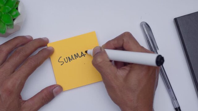 A man writing SUMMARY on orange sticky note