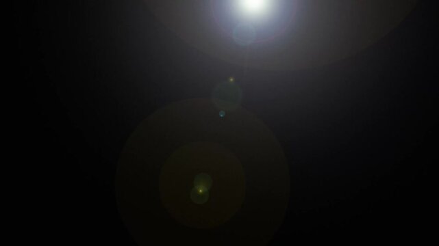 Optical lens flare effect with cinematic light rays and glowing flash, abstract sunburst background for VFX overlays, transitions, highlights and titles