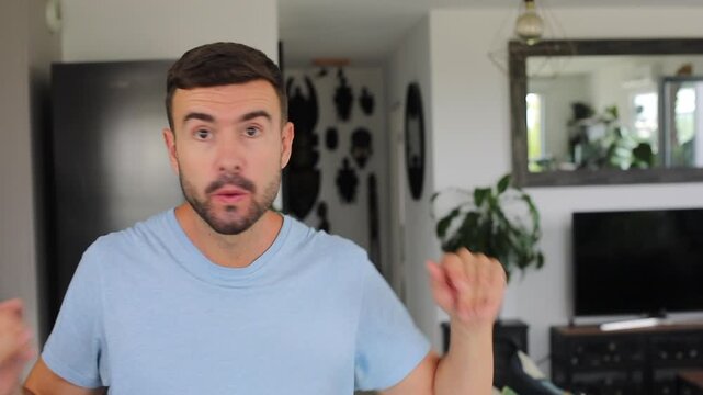 Man whistling and gently dancing to an easy rhythm in front of the camera before smiling
