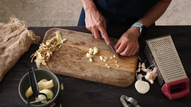 Close-Up Top View Of Woman Slicing Garlic