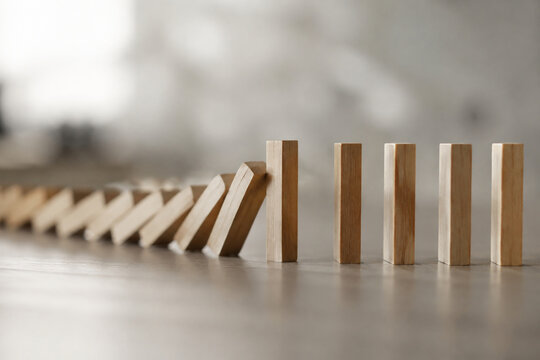 A chain of falling dominoes interrupted, focusing on the break point.