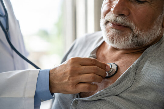 Doctor performing a routine medical examination and listening to an older patient&rsquo;s chest with a stethoscope