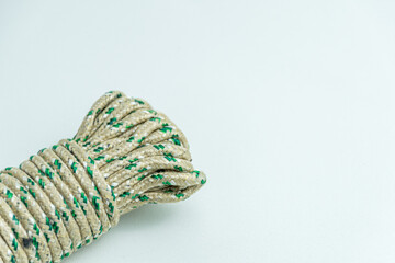Rolled bundle of green and white twisted string rope isolated on white background © Arfin Studio