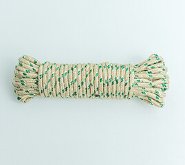 Rolled bundle of green and white twisted string rope isolated on white background © arbi wiratama