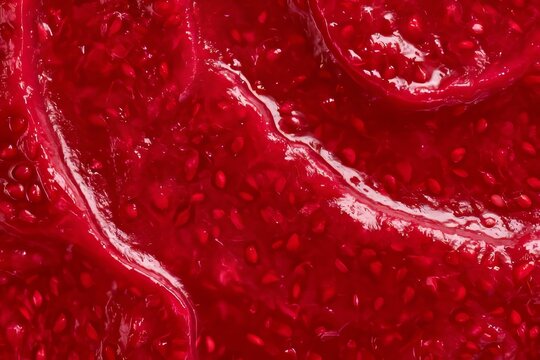 Strawberry jam spread on a clean surface in a kitchen setting during the afternoon