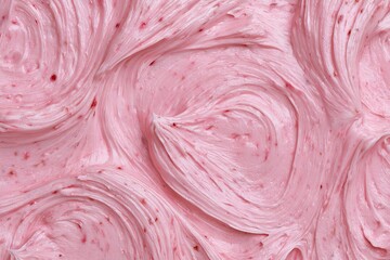 Obraz premium Creamy pink frosting spreads on a cake with swirl patterns
