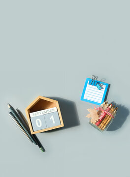September calendar. Wooden calendar block with date 1 September, pencils, empty note on grey background. top view. copy space. Template for design
