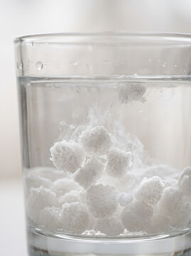White flocculant particles settling at bottom of glass during water purification