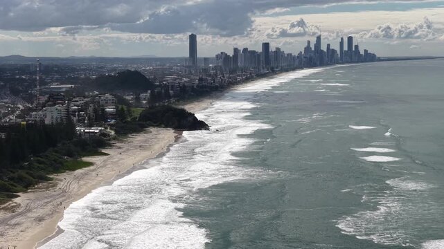 Burleigh Heads drone flight along the beach with the city skyline beyond, Gold Coast, Queensland Australia