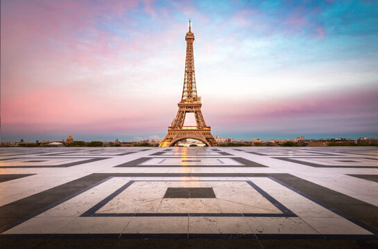 Paris, France - 29 April 2023: View of the Eiffel Tower rising above the Trocadero esplanade at sunset with a colorful sky.