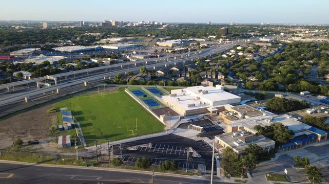 Neff Middle School educational buildings, sports complexes border Loop 410 along Evers Road in Bexar County. Campus football fields meet multi lane highway viaducts in San Antonio, Texas