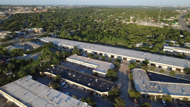 Industrial flex warehouses, lush tree canopies border Evers Road near Leon Valley across Bexar County. Commercial distribution bays meet suburban residential grids in San Antonio, Texas