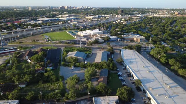Commercial flex buildings, educational grounds border Evers Road near Loop 410 across Bexar County. Suburban logistics facilities meet middle school campuses across San Antonio, Texas