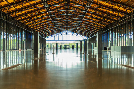 Richmond, United States - 08 August 2024: View of the historic Main Street Station train shed interior featuring exposed steel trusses, wooden ceiling, and polished concrete floors.