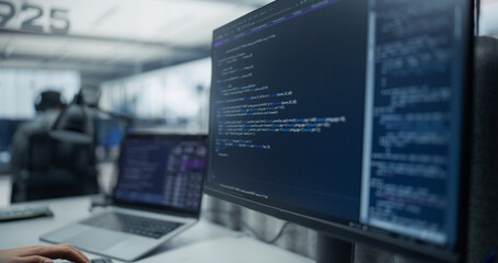 Close-up of a Computer Screen Showing Backend Program Code and Sql Database Query Next to a Laptop...