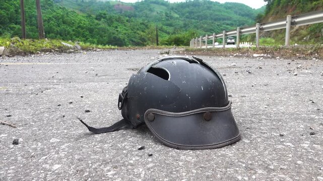 Signs of a tragedy. A broken motorcycle helmet is lying on the side of the highway. traffic accident