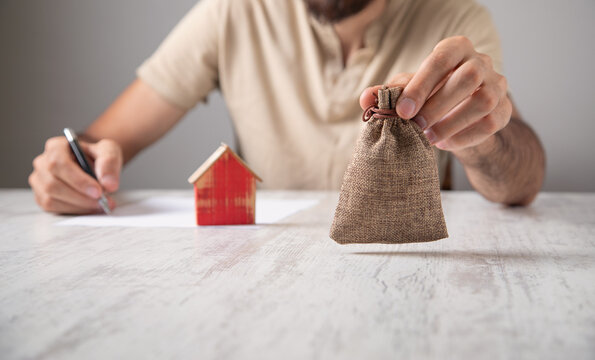 Man with a money bag and house model.