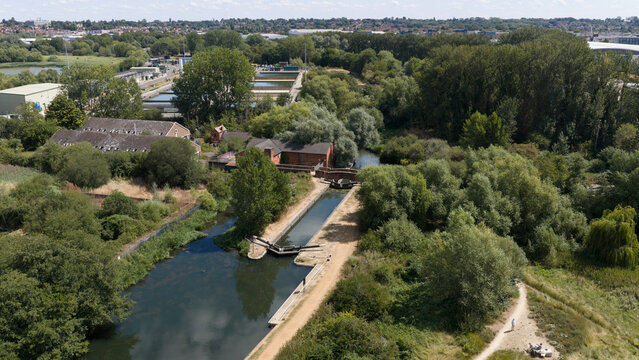 Aerial view of Fobney Pumping Station surrounded by lush greenery and canal locks in Reading, England, United Kingdom.