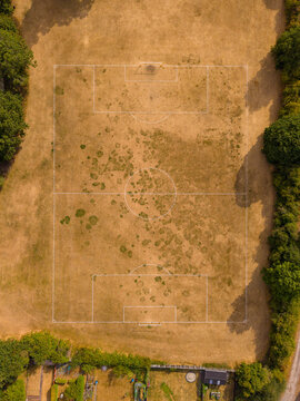 Aerial view of a dry, patchy football pitch in Creswell, Stafford, England, United Kingdom.