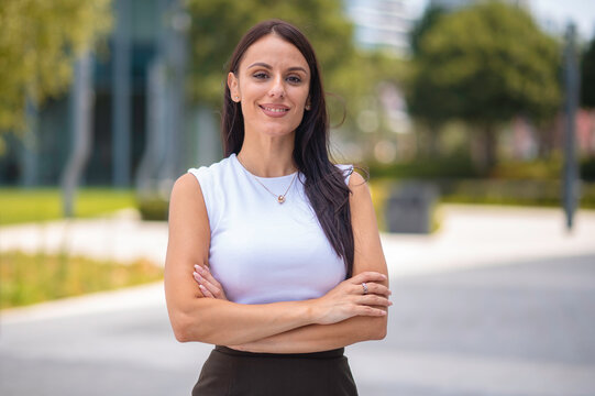 Professional businesswoman smiling with arms crossed outdoors
