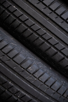 View of black rubber car tires with detailed tread patterns stacked together in Riga, Latvia.