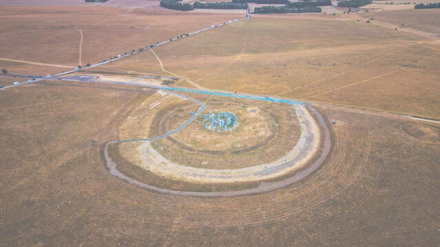 Aerial view of Stonehenge, the prehistoric monument, surrounded by vast grassy fields and ancient earthworks in Salisbury, England, United Kingdom.