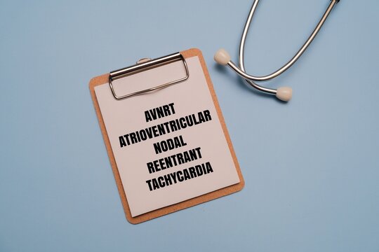 AVNRT - ATRIOVENTRICULAR NODAL REENTRANT TACHYCARDIA text on clipboard with stethoscope on blue background. Medical concept of heart rhythm disorder, cardiology diagnosis, treatment, and healthcare