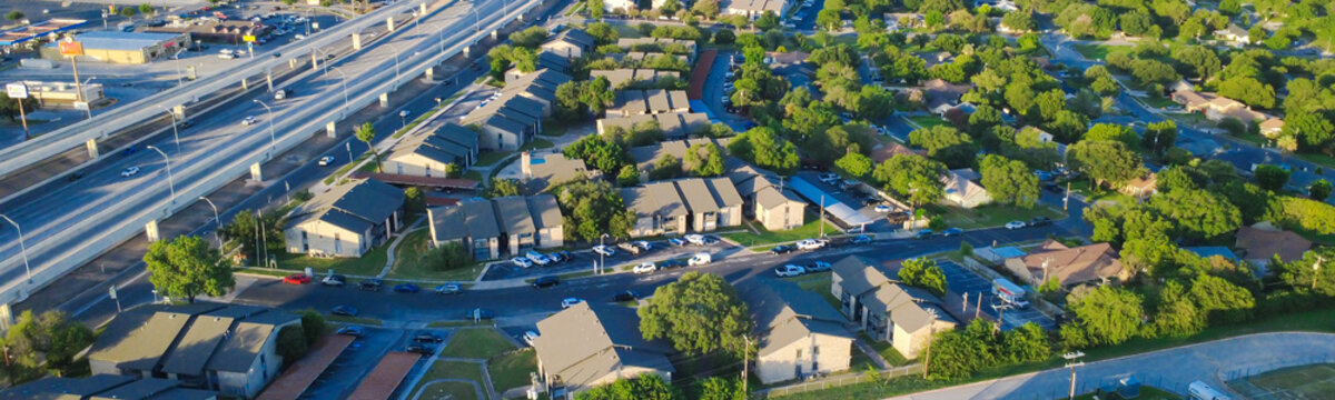 Elevated freeway structures, suburban housing developments border Loop 410 along Evers Road. Multi lane transport corridors intersect residential districts across San Antonio, Texas