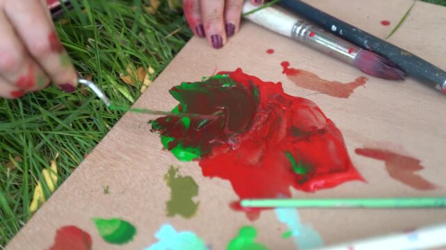 Woman painting outdoors on a canvas and easel and artist palette