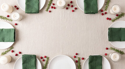 Winter holiday dining table setup featuring plates, green napkins, candles, cranberries, and rosemary on a linen tablecloth