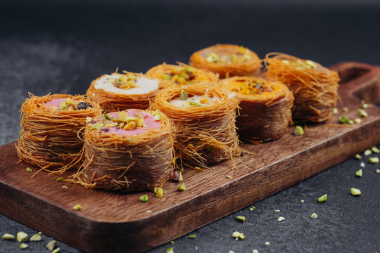 Middle Eastern Kataifi desserts arranged on a wooden board