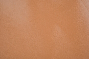 Soft peach leather texture close up with matte smooth surface and natural grain detail