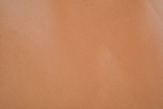 Soft peach leather texture close up with matte smooth surface and natural grain detail