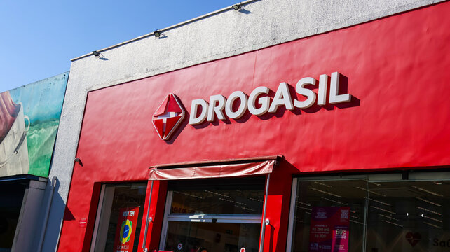 Fachada de unidade da rede Drogasil com letreiro vermelho e entrada da farm&aacute;cia, registro de com&eacute;rcio e sa&uacute;de em &aacute;rea urbana de Mogi das Cruzes, S&atilde;o Paulo, Brasil, em 22 de agosto de 2026