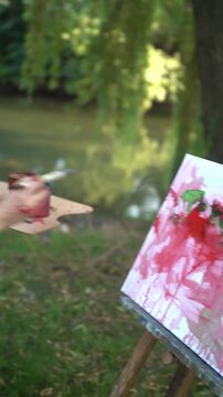 Woman painting outdoors on a canvas and easel and artist palette