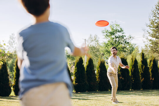 Father and son playing frisbee in park