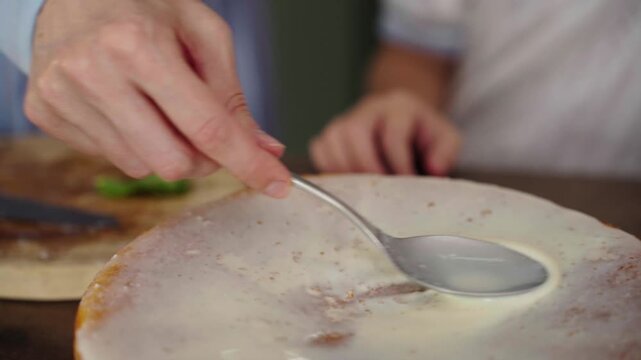 Mother and daughter bake layered cake together in cozy sunlit kitchen, 25 fps