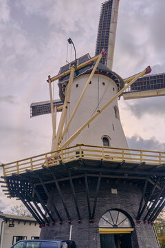Traditional Dutch windmill 'De Nieuwe Molen' in Nijmegen Netherlands historical flour manufacturing and renewable energy heritage The old mill building with its large sails stands on a cloudy sky