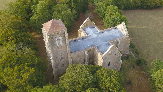 Aerial view of the historic Butte de Thil collegiate church surrounded by lush trees and rural landscape in Vic-sous-Thil, Bourgogne-Franche-Comte, France.