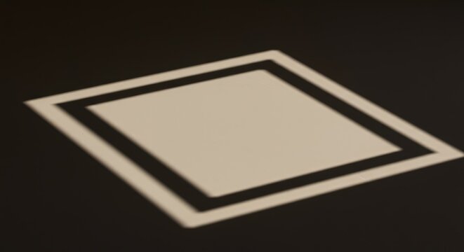 A geometric shadow projection casts a stark, empty rectangular space onto a smooth, textured surface, serving as a conceptual placeholder for design elements ,stage ,space ,minimalist