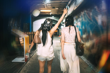 Fototapeta premium Rear view of two young asian woman hang out at Khao san walking street hipster style