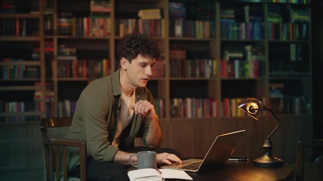 Concentrated young male freelancer works on online project in a coffee shop