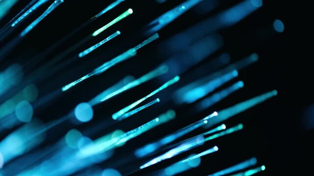 Macro view illuminated optical fiber ends changing color from purple to green and blue.